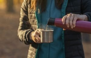 Profile | The Menopause Association close up of female hands pouring tea into mug WE89852 | The Menopause Association